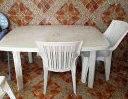 Big white plastic table with 5 white chair...